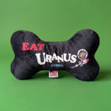 Black plush bone dog toy with “Eat Uranus (fudge)” text and character graphic on green background