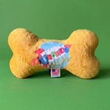 Yellow plush bone dog toy with Uranus Fudge Factory logo on green background