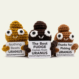 Trio of Emotional Support Poop crochet plushies with big eyes and stitched smiles holding Uranus Fudge Factory signs