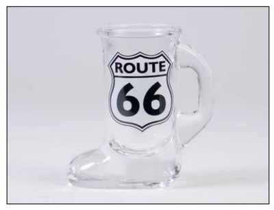A clear glass souvenir shot glass shaped like a boot with a handle featuring a black and white Route 66 shield