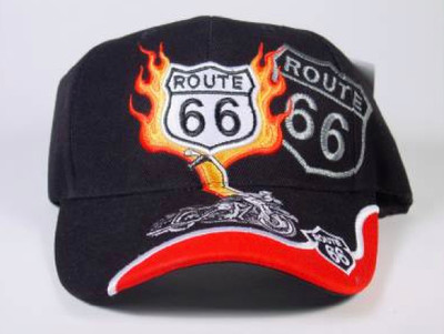 A black baseball cap against a plain light background. The front of the crown features a white embroidered Route 66 shield surrounded by vibrant orange and yellow flames. 
