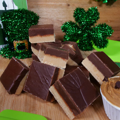 Peanut Butter Choclate Fudge from Uranus on a cutting board with ST. Patrick's Day decor.