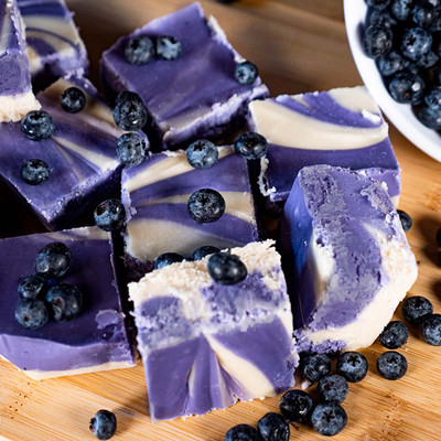 A pile of vibrant purple and white swirled Blueberry Cheesecake Fudge, freshly made at the Uranus Fudge Factory.