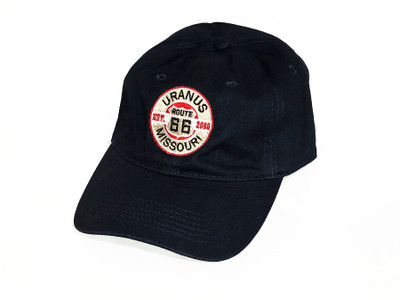 A black baseball cap against a plain white background. The front of the hat features a distressed, circular embroidered logo. The design includes a white Route 66 shield inside a red circle, crossed by a black horizontal bar reading "EST. 2000". The outer white ring of the logo displays the word "URANUS" arched across the top and "MISSOURI" arched across the bottom in bold black text.