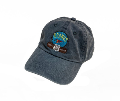 Faded blue baseball cap featuring an embroidered Uranus Missouri space rocket patch on a white background Uranus Fudge Factory.