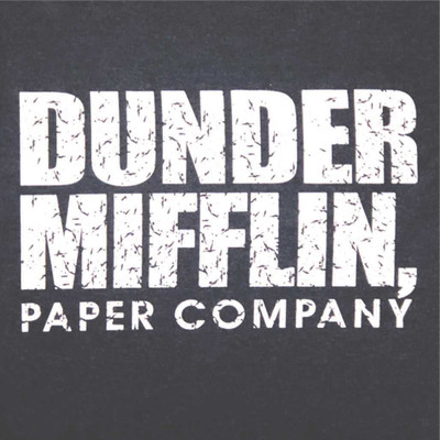 A close-up of a text-based graphic on a dark grey t-shirt. The design features the stacked text "DUNDER MIFFLIN," in a large, bold, white, distressed font. Below it, the words "PAPER COMPANY" are printed in a smaller, matching distressed white font.