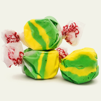 Three colorful wrapped Pineapple saltwater taffy candies stacked together on a plain white background by Uranus Fudge Factory.