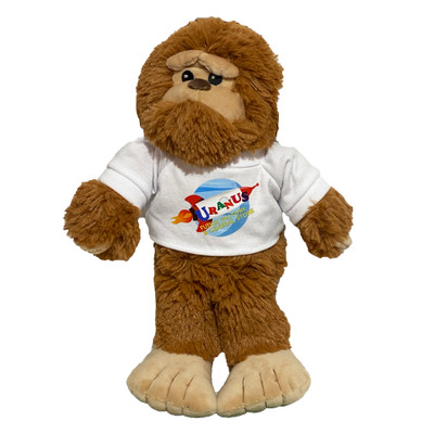 Stuffed brown Bigfoot toy wearing a branded shirt isolated on a solid white background by Uranus Fudge Factory.