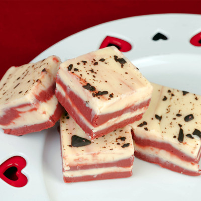 Red velvet fudge squares topped with chocolate flakes served on a heart cut plate from Uranus Fudge Factory.