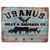 A distressed metal souvenir sign for Uranus Meat & Sausage Co. featuring butcher cut animal illustrations and a humorous slogan