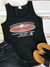 A flat lay photo of the black Uranus Fudge Packer tank top paired with jean shorts and sandals