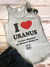 A flat lay of the black I Heart Uranus tank top paired with jean shorts and sunglasses