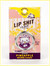 Retail packaging for "Lip Shit" lip balm in Pineapple Brown Sugar flavor. The card features a pink and yellow retro illustration of a flower garden and a kitten. A circular silver tin is mounted in the center, featuring an adorable drawing of a kitten eating an ice cream cone with the words "Yummy Pineapple Brown Sugar."