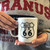 A person displaying a white Route 66 shield graphic mug from Uranus Fudge Factory.