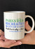 A person holding a white Parks & Recreation City of Uranus novelty mug from Uranus Fudge Factory.