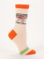 An off-white novelty crew sock featuring orange trim and text that reads "RINGMASTER OF THE Shit Show."