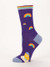 Side view of the purple novelty sock decorated with multiple small scattered rainbow graphics and light blue accents.