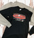 Black and grey long sleeve shirts with a novelty Fudge Packers design from Uranus Fudge Factory.