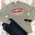 Grey long sleeve shirt featuring a novelty Fudge Packers graphic print from Uranus Fudge Factory.