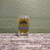 A clear Uranus Fudge Factory rocket logo shot glass filled with a bubbly drink against a textured green background