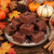 Chocolate fudge squares with chocolate curls on a plate with fall pumpkins and leaves
