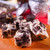 Cookies and cream fudge chunks on a board with blurred kitchen details by Uranus Fudge Factory.