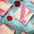 Pink and white swirled raspberry fudge squares on green paper from Uranus Fudge Factory.