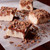 Pieces of toffee fudge with crushed candy crumbles on parchment paper from Uranus Fudge Factory.