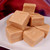 A stack of creamy peanut butter fudge cubes on a plate from Uranus Fudge Factory.