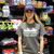 Woman wearing a grey novelty t-shirt with a humorous canoe paddle faster quote.