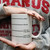 Person holding a white coffee mug with lines marking funny coffee levels.