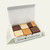 Reduced sugar fudge sampler in open box with chocolate, vanilla, peanut butter, and peanut butter chocolate pieces on an off-white background.