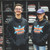Two people wearing and displaying the front of the black Uranus Liquors hoodies from Uranus Fudge Factory