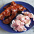 A blue plate features several strips of crispy, glazed bacon next to a pile of pink and orange swirled saltwater taffy in wax paper wrappers, illustrating the maple bacon flavor profile.