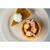 Pumpkin pie slice with whipped cream next to a dish of matching saltwater taffy by Uranus Fudge Factory.