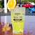 Yellow drink in a Uranus General Store pint glass on a table with a blurred parking lot background at Uranus Fudge Factory.