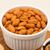 Red Hot Route 66 Redneck Nutz spicy peanuts in a white bowl on wooden board. 