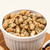 Ghost Pepper Redneck Nutz spicy peanuts in a white bowl on a wooden board.