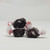 Three pieces of black salt water taffy candies with white details wrapped in wax paper.