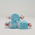 Three pieces of blue salt water taffy candies with white details wrapped in wax paper.