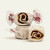 Three pieces of white salt water taffy candies with brown swirls wrapped in wax paper.