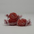  Three pieces of red salt water taffy candies with white swirls wrapped in wax paper.