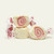 Three pieces of white salt water taffy candies with pink swirls wrapped in wax paper.