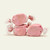 Three pieces of pink salt water taffy candies with speckles wrapped in wax paper.