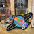 Planet Uranus sticker displayed on a wooden shelf next to souvenir shot glasses at Uranus Fudge Factory.