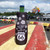 Route 66 bottle sleeve holding a glass bottle on a red table with a blurred parking lot background by Uranus Fudge Factory.