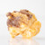 Close-up of a peanut butter covered caramel corn piece on a white background by Uranus Fudge Factory.