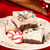 White chocolate peppermint fudge slice with crushed peppermint pieces and a chocolate cookie crunch base on a white background.