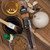 Honey BBQ beef stick package surrounded by raw ingredients and a basting brush from Uranus Fudge Factory.
