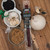 Peppered beef stick package surrounded by brown sugar, black peppercorns, and garlic from Uranus Fudge Factory.